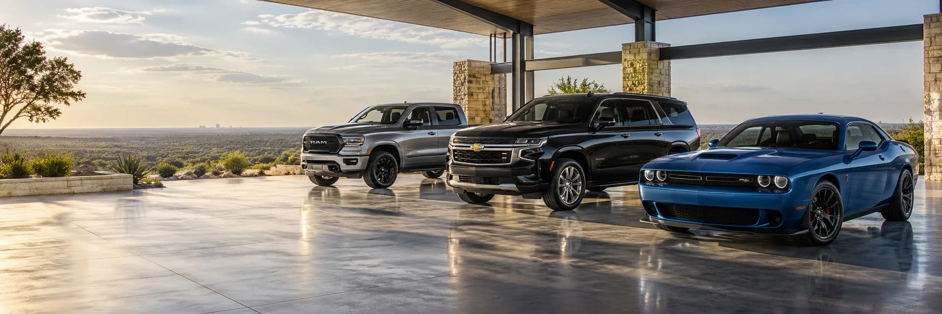 Ram pickup, Chevrolet SUV and Dodge Challenger in an open presentation pavilion